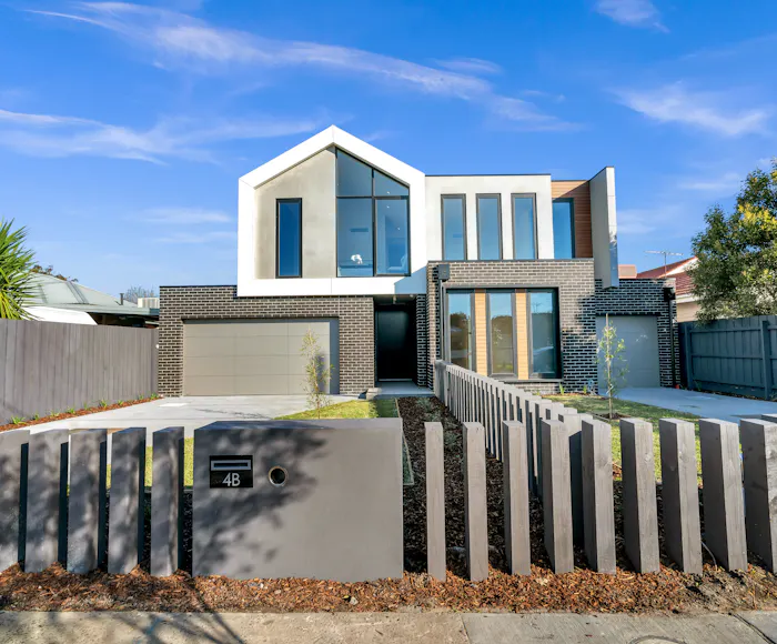 Contemporary two-storey home with gabled roof and timber screen fence